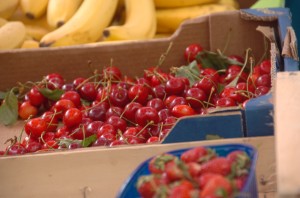 Boxes of cherries and bananas in a supermarket